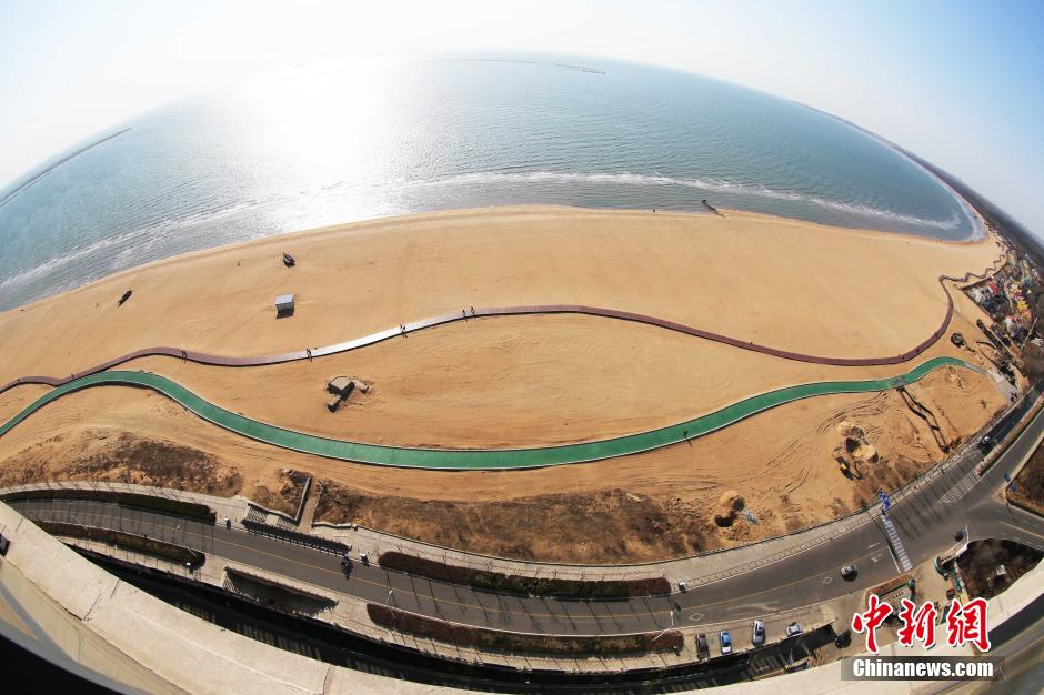3月13日，秦皇島萬(wàn)米臨海沙灘木棧道。據(jù)了解，該木棧道全長(zhǎng)約4200米，與北戴河區(qū)原有的7500米木棧道對(duì)接后全線總長(zhǎng)度1.17萬(wàn)米，整個(gè)木棧道東起秦皇島體育基地游船碼頭，西至北戴河濕地公園，呈波浪形蜿蜒10.4公里海岸線。 中新社發(fā) 曹建雄 攝 CNSPHOTO